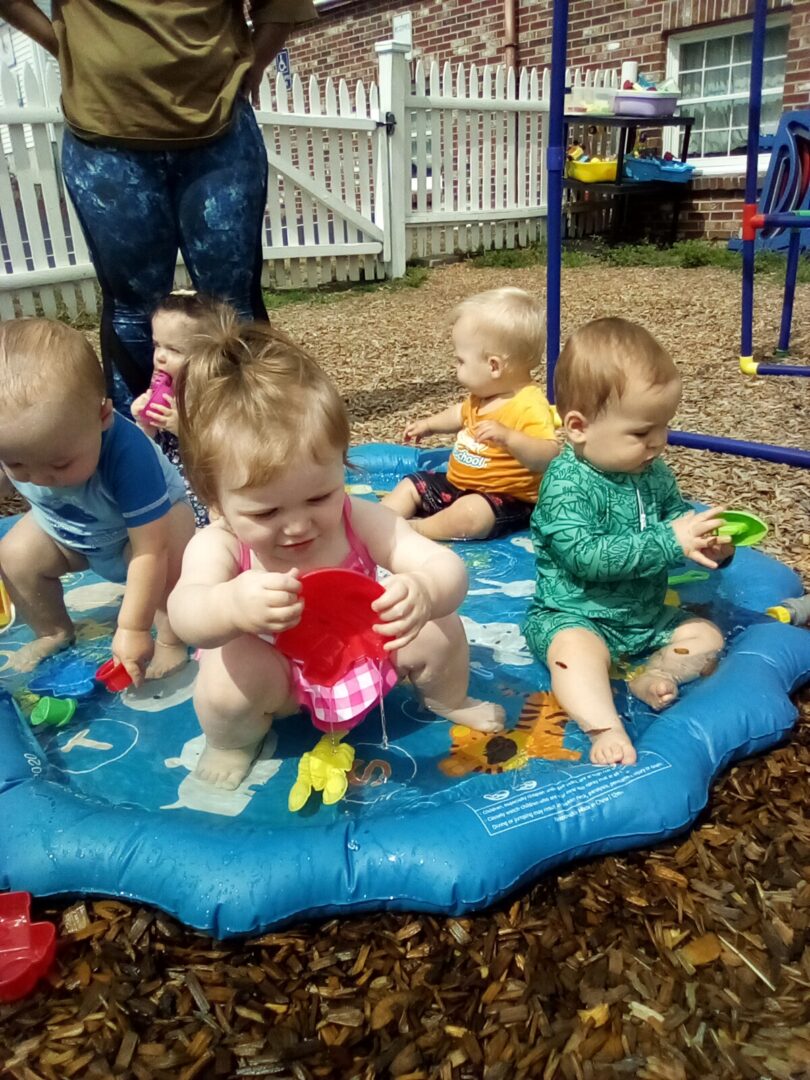 A picture of babies sitting in circle and playing with water